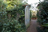 Wooden gate at entrance to topiary garden. East Ruston Old Vicarage Gardens, Norfolk