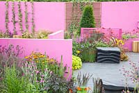 Modern garden with screens. Planting includes Coreopsis 'Early Sunrise', Delphinium 'King Arthur', Achillea 'Walther Funcke', Crocosmia 'Lucifer', Heuchera 'Lime Marmalade' and Heuchera 'Obsidian'