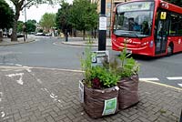 Pop-up Garden Mildmay, two builders bags full of plants with urban greening sign and passing bus, Islington - Chelsea Fringe Festival, London 2012 
