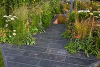 Slate patio area softened with grass borders - 'The Landform Garden' - Gold medal winner and Best Summer Garden - RHS Hampton Court Flower Show 2012 