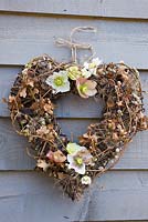 Rustic winter wreath with helleborus orientalis flowers, salix and quercus foliage 
