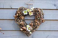 Rustic winter wreath with helleborus orientalis flowers, salix and quercus foliage 