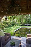 Relaxing area with contemporary furniture on patio by the pond