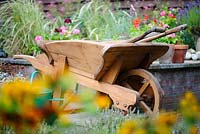 Wooden wheelbarrow in a summer garden