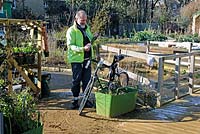Man unlocking his bike from a Plantlock in King Henry's Walk Garden, an award winning community allotment site in the London Borough of Islington
