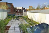 Roof garden with paved patio, border with leaky pipe irrigation hose, galvanised post, screen and firepit. Planting includes Sedum, Salvia, Lavandula and Achillea - The Onion Flats in Philadelphia.USA's First LEED Homes Platinum Residential Duplex Project, 145 - 151 W Laurel Street, Northern Liberties, Philadelphia, PA, USA