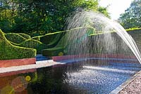  The Reflecting Pool being sprayed to settle surface debris from the pool - Veddw House Garden, Monmouthshire, Wales