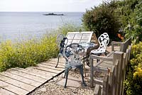Table and chairs with sea view, Coastal allotment, Mousehole, Cornwall, July, summer