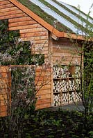 Eco friendly house with sedum planted roof, solar panels and log store