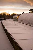 Coldframes, polytunnels and greenhouse covered in snow in the nursery at Glebe Cottage