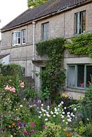 Stone cottage with roses, Wisteria, foxgloves, Dahlia and poppies 
