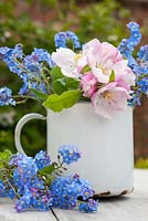 Apple blossom and forget me nots in an old enamel cup
