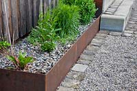 Planting in corten steel troughs mulched with gravel, Buxus, Liatris and Penstemon