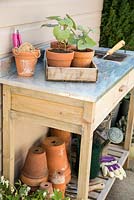 Assortment of gardening tools and equipment on a potting bench