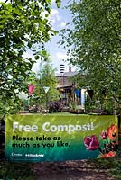 Banner saying Free Compost, Please take as much as you like. Dalston Eastern Curve Garden, an urban community garden, London Borough of Hackney, UK