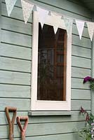 Step by step of making garden bunting - The finished bunting hanging on a painted summerhouse