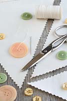 Step by step of making garden bunting with vintage linens and buttons - Make use of any plain areas of linen by sewing on old buttons
