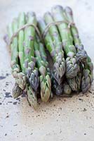 Asparagus in tied bundle on table