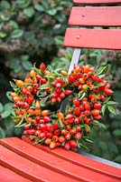 A heart shaped Rosehip wreath on a red chair