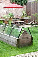 Glasshouse made of used window glass with open bottom. 