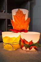 Decorative candle holders wrapped in autumnal leaves
