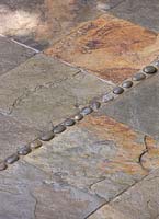 Slate tile floor inlaid with decorative pebbles - small town garden, Brighton, UK 