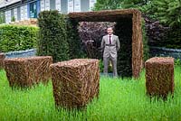 As Nature Intended Garden, Silver gilt medal winner, Chelsea Flower Show 2013. Jamie Dunstan standing between woven willow sculptures and yew hedging.