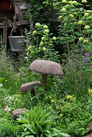Wooden toadstools, treehouse, Digitalis,  Antirrhinum - Snapdragon, Cowslips and Buttercups in The NSPCC Garden of Magical Childhood