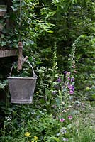 The NSPCC Garden of Magical Childhood, treehouse, galvanised bucket, Digitalis - Foxgloves, Hedera and Primula veris - Cowslips