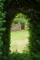 Window cut into the yew hedge gives views onto the lawn and the entrance to the Hidden Garden. 