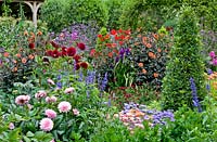 Colourful Summer borders with roses, dahlias and salvia. 