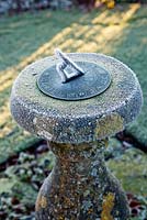 Frosted stone sundial at dawn. Wollerton Old Hall, Shropshire