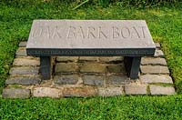 Seat engraved with words Oak Bark Boat. Little Sparta, Dunsyre, Lanark, Lanarkshire. Scotland. 