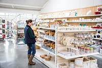 Woman browsing selection of household items at a garden nursery