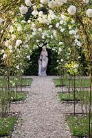 Vesta's Garden with statue and white overhanging Rosa on arches
