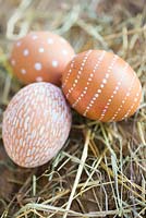 Easter display of decorated eggs amongst straw
