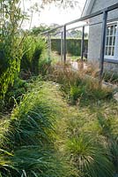 Beds of ornamental grasses. Sporobolus heterolepis, Molinia caerulea 'Dauerstrahl', Panicum virgatum Rehbraun.