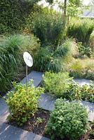 Contemporary designed herb garden with sundial.