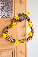 Woven Daffodil wreath hanging on door. Narcissus 'Tete a tete'