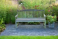 Wooden bench. Prairie planting. Panicum virgatum 'Shenandoah', Helenium 'Rubinkuppel',   Lobelia 'Tania', Molinia caerulea 'Edith Dudszus'. 