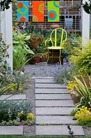 View along stone slab path to seating area with potted plants.