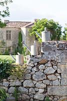 Old watering cans on stone wall of chateau in France (Chateau Rigaud)