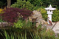 Asian pond with stone lantern and decorative heron