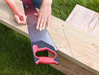 Using a pencil and saw to create a zig-zag shape on wood - creating a deck