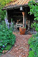 Gravel and crock path leading to potting shed.  Dial A Flight, RHS Chelsea Flower Show 2014. 