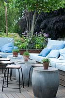 Rooftop garden with seating and galvanised tubs used as tables 