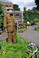 Wartime scarecrow of British soldier with helmet and hoe on a Dig for Victory themed allotment plot designed by one of the students at Kew Gardens.  