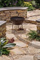 Crazy paving, rustic irregular slabs and circular dry stone wall with Purbeck stone top and barbeque, Halo, RHS Hampton Court Flower Show 2014