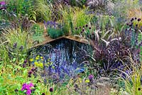 The One Show Garden. Extensive planting of ornamental grasses and flowering perennials around small pool.