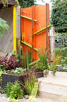 Gold. Best summer garden. A Space to connect and to grow. Design: Jeni Cairns and Sophie Antonelli. Waterwall made of metal tubes.